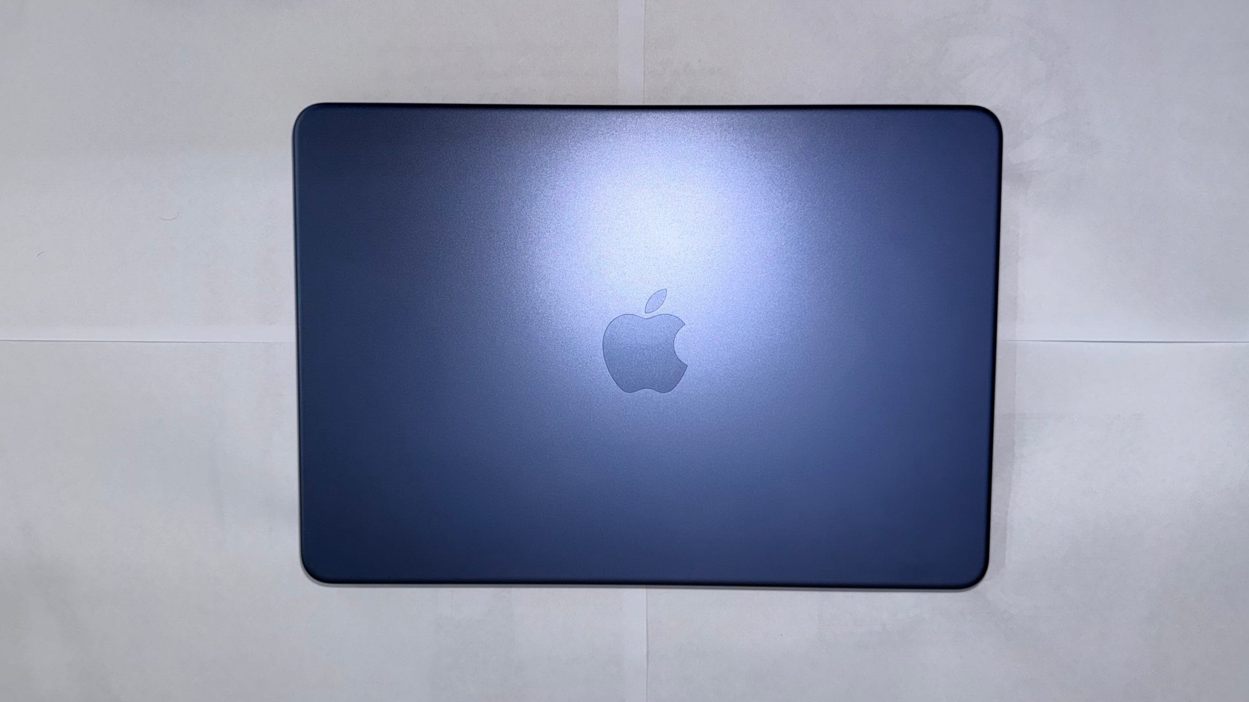 Apple MacBook Neo in Indigo color with aluminum lid and centered Apple logo